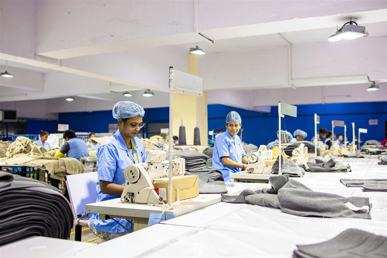 Garment workers manufacturing textiles at an Acme production facility
